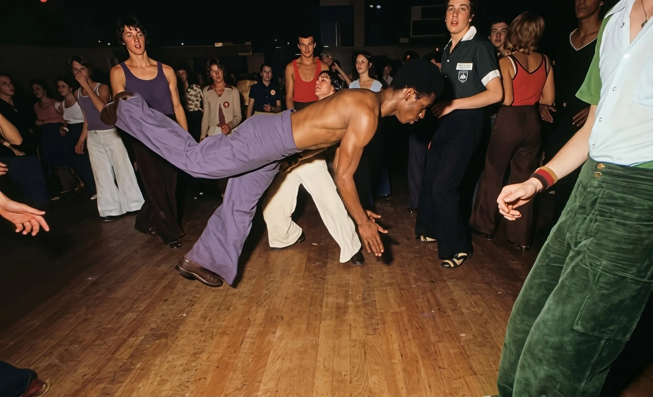 A dancer kicks out across a crowded Northern Soul dance floor, a still from the film Northern Soul
